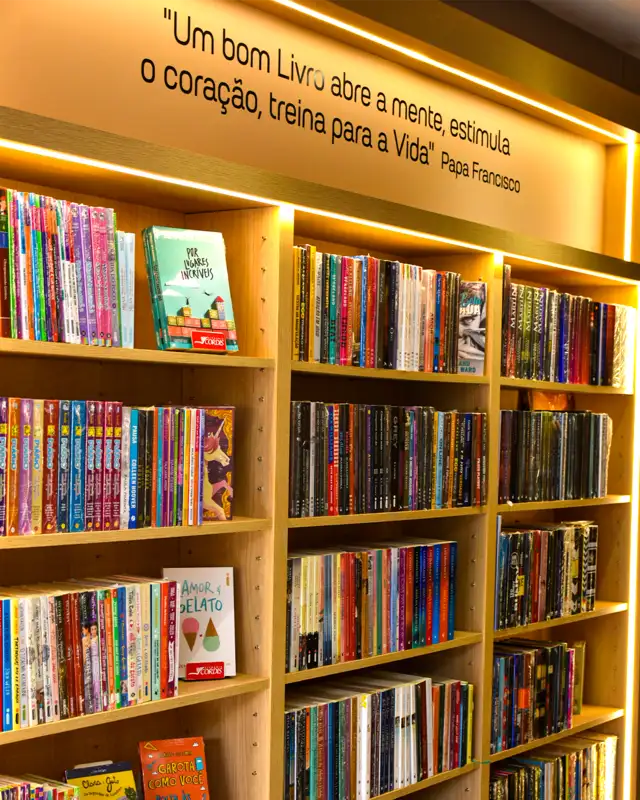 Estantes de livros da Livraria Cordis com a frase do Papa Francisco sobre a leitura